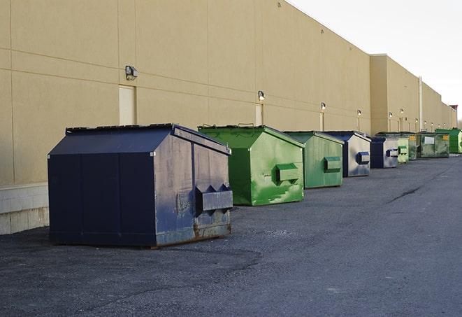 a pile of demolition waste sits beside a dumpster in a parking lot in Clinton UT